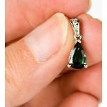 A platinum pear shape green tourmaline and diamond set pendant.