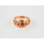A 9ct rose gold Edwardian style pierced three stone garnet ring, size O, 3g.