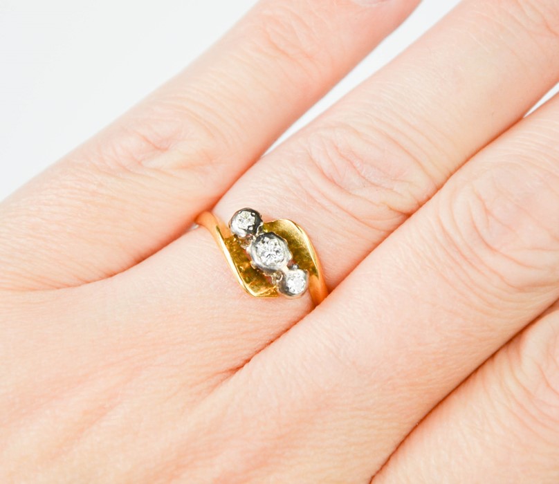 An 18ct gold and three stone diamond ring, size K.