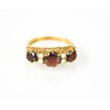 An Edwardian 18ct gold, garnet and pearl ring. Size O1/2 2.8g