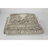 A silver rectangular dressing table box, London 1905 by William Comyns, embossed with scrollwork,