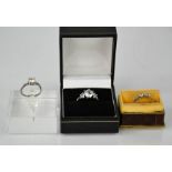 A silver trilogy ring, set with white paste stones, size N½, 0.1toz, a silver solitaire ring, and