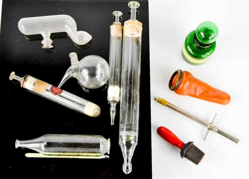 A group of chemists accessories, to include glass vials, tube feeder, duck billed nasal douche,