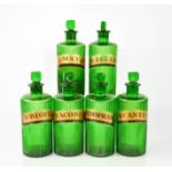 A group of six antique green glass apothecary bottles with latin labels, 17cm high.