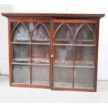 An early 19th century mahogany glazed wall cabinet, with gothic style arched astragals, enclosing