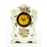 A ceramic mantle clock decorated with flowers, and having an Arabic dial, 26cm high.