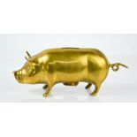A vintage brass money box in the form of a pig.