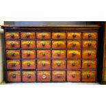 An antique apothecary cabinet, painted with labels for each of the thirty graduated drawers, 73 by