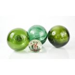 Three green glass fisherman's floats, one impressed with an anchor, together with a glass