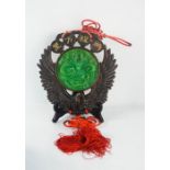 A Chinese wall hanging, carved with character marks, to bring luck, the jadeite carved centre