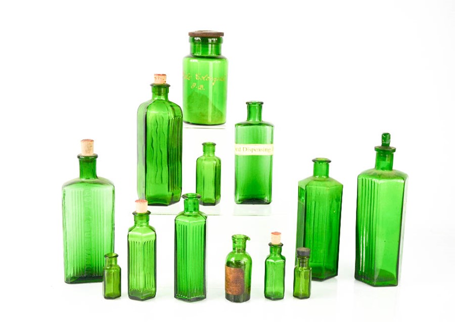 A group of vintage green glass medicine bottles, the tallest 20cm high.