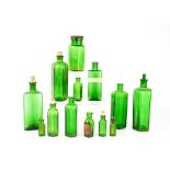 A group of vintage green glass medicine bottles, the tallest 20cm high.