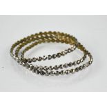 Three matching 18th century Georgian bright cut steel bangles or bracelets, multi-faceted stones and