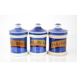 Three ceramic antique apothecary jars, each with latin labels on blue ground, 13cm high.