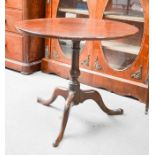 An 18th century oak pedestal tilt top table, on a tripod base with cabriole legs and pad feet,