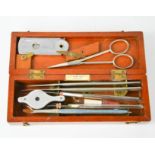 A vintage Arnold & Sons of London chemists box containing scalpels, eye loop, scissors and other