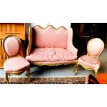 A 19th century French pink upholstered settee and matching balloon back chairs.