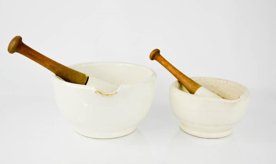 Two vintage ceramic pestle and mortars, the pestles having wooden handles, the largest measures 13