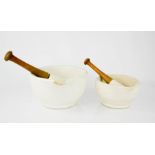 Two vintage ceramic pestle and mortars, the pestles having wooden handles, the largest measures 13