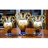 A 19th century garniture of vases, hand painted with floral groups to one side and landscapes to the
