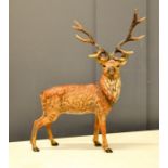 A reproduction cast metal cold painted figure of a stag