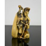 A Chinese carved ivory figure holding a stick, signed to the base, circa 1900, 8cm high.