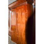 A Victorian mahogany wardrobe with arched doors, raised on a plinth base, 203 by 102 by 65cm