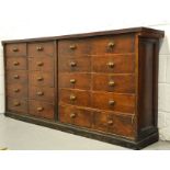 An antique pine collectors cabinet composed of twenty graduated drawers with turned wooden