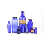 A group of blue glass vintage medicine / apothecary bottles.