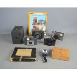 A group of cameras to include a 2A Brownie, Kodak, and a boxed The Trident film maker.