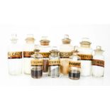 Eight antique glass apothecary bottles with stoppers and latin labels, the tallest 18cm high.