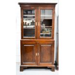 An 18th century oak cupboard, the glazed upper section having height adjustable shelves, above two