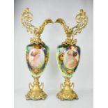 A pair of 19th century ewers, with decorative gilt metal bases and handles, the central roundels