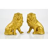 A pair of gilded porcelain lions, circa 1900, 8½cm high.