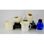 Two vintage feeding cups and two ceramic sputum mugs and a blue glass sputum flask.
