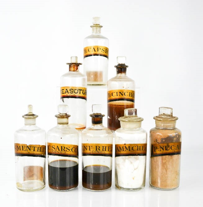 Eight antique apothecary jars with stoppers and latin labels, tallest 17cm high.