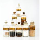 Eight antique apothecary jars with stoppers and latin labels, tallest 17cm high.
