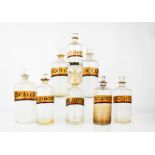 Eight glass antique apothecary bottles, with stoppers and latin labels, tallest 23cm high.