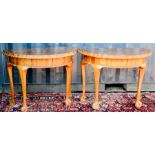 A pair of demi-lune hall tables, with shaped tops and raised on cabriole legs with ball & claw