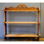 A late 19th century mahogany wall shelf, with pegged shelves, and shaped and pierced top and end