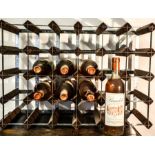 Eight bottles of Bandol 1980 rose wine, in a wine rack.