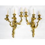 A pair of French gilt brass wall lights, in the Rococo style, each composed of three foliate