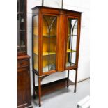 An Edwardian glazed cabinet, with bow front centre, inlaid with decoration.