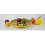 A group of ceramic fruits and a mediterranean plate.
