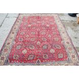 A large 20th century red ground rug, 220 by 450cm.