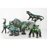 A group of Canadian green glazed figurines to include a dog, lion, dolphins etc