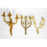 Three French gilt brass wall lights, one in the Rococo style with three branches, and two others