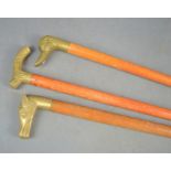 Three walking sticks with brass animal form handles.