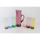 A mid-century set of six coloured glasses and a jug.