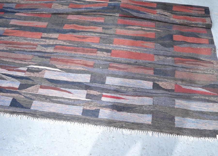 A large hand woven rug, of modern design. 308cm x 252cm